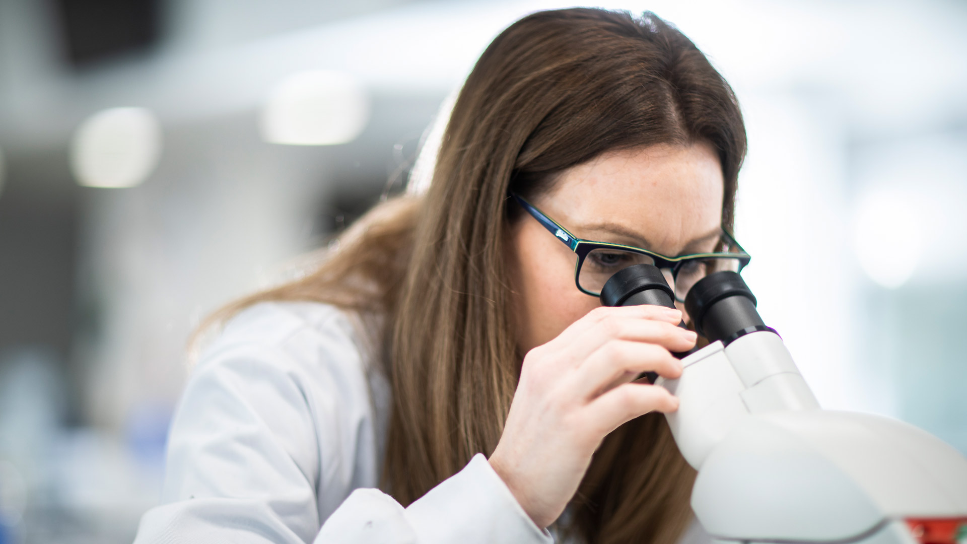 Student looking at sample in microscope