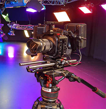 A video camera on a tripod in a studio