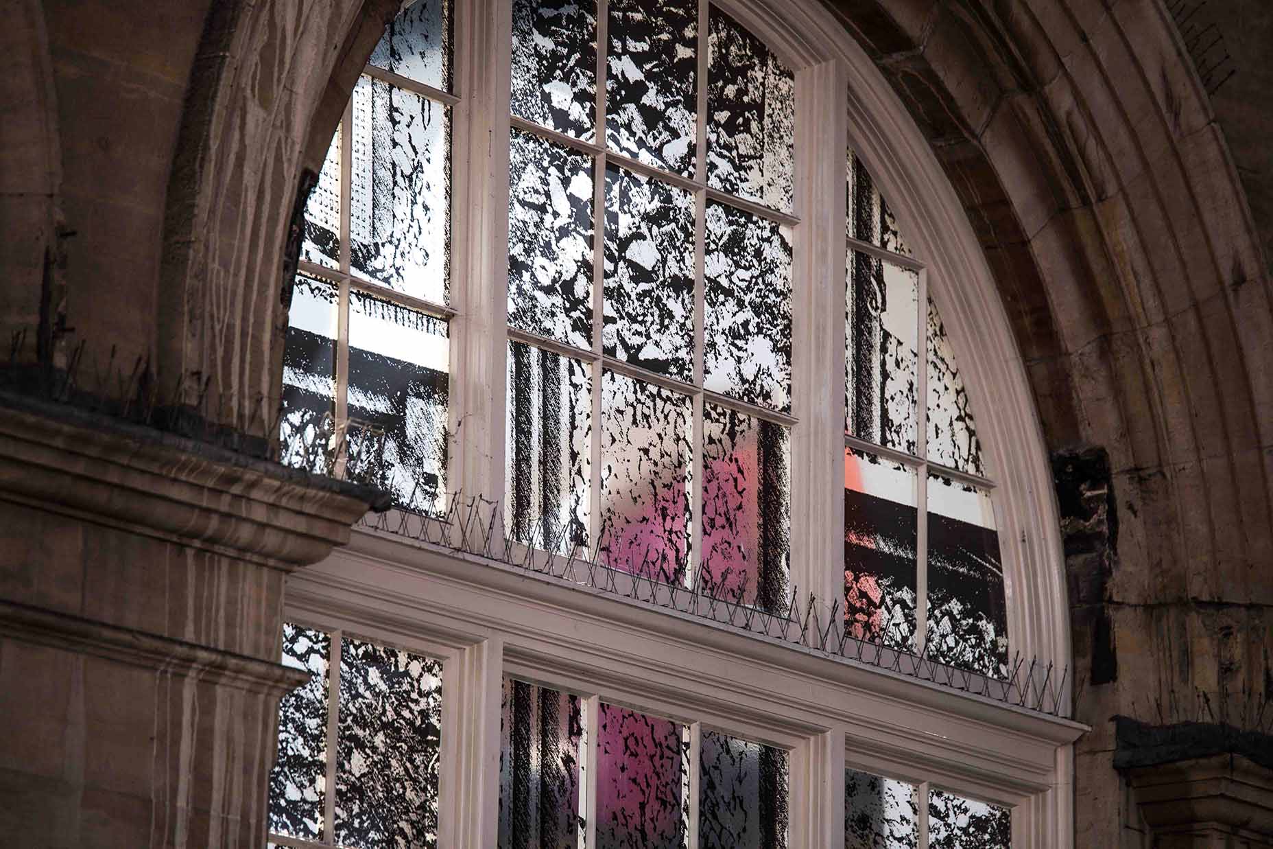 An arch window with black abstract print on the windows.